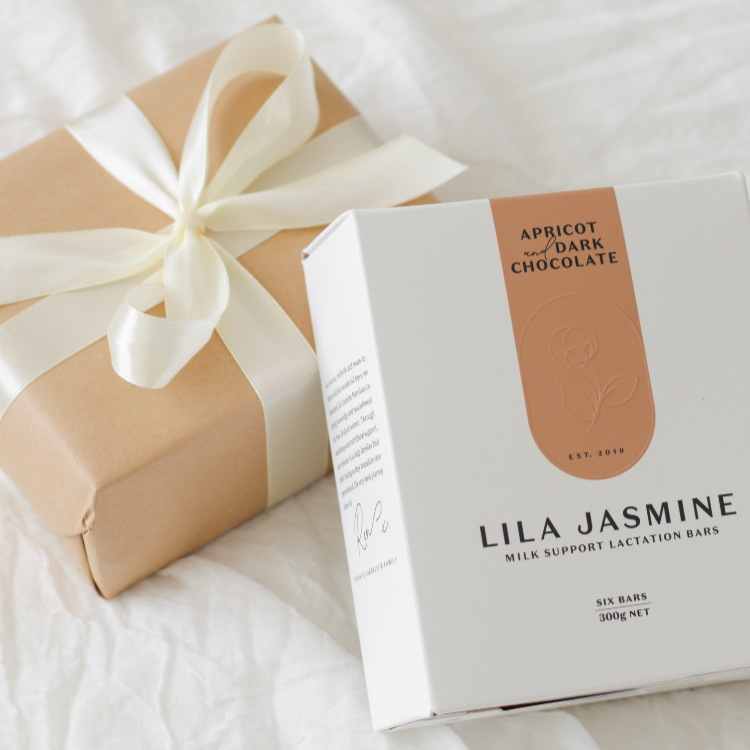 Gift box with a bow and a product packaging labeled 'Lila Jasmine' on a white textured surface.