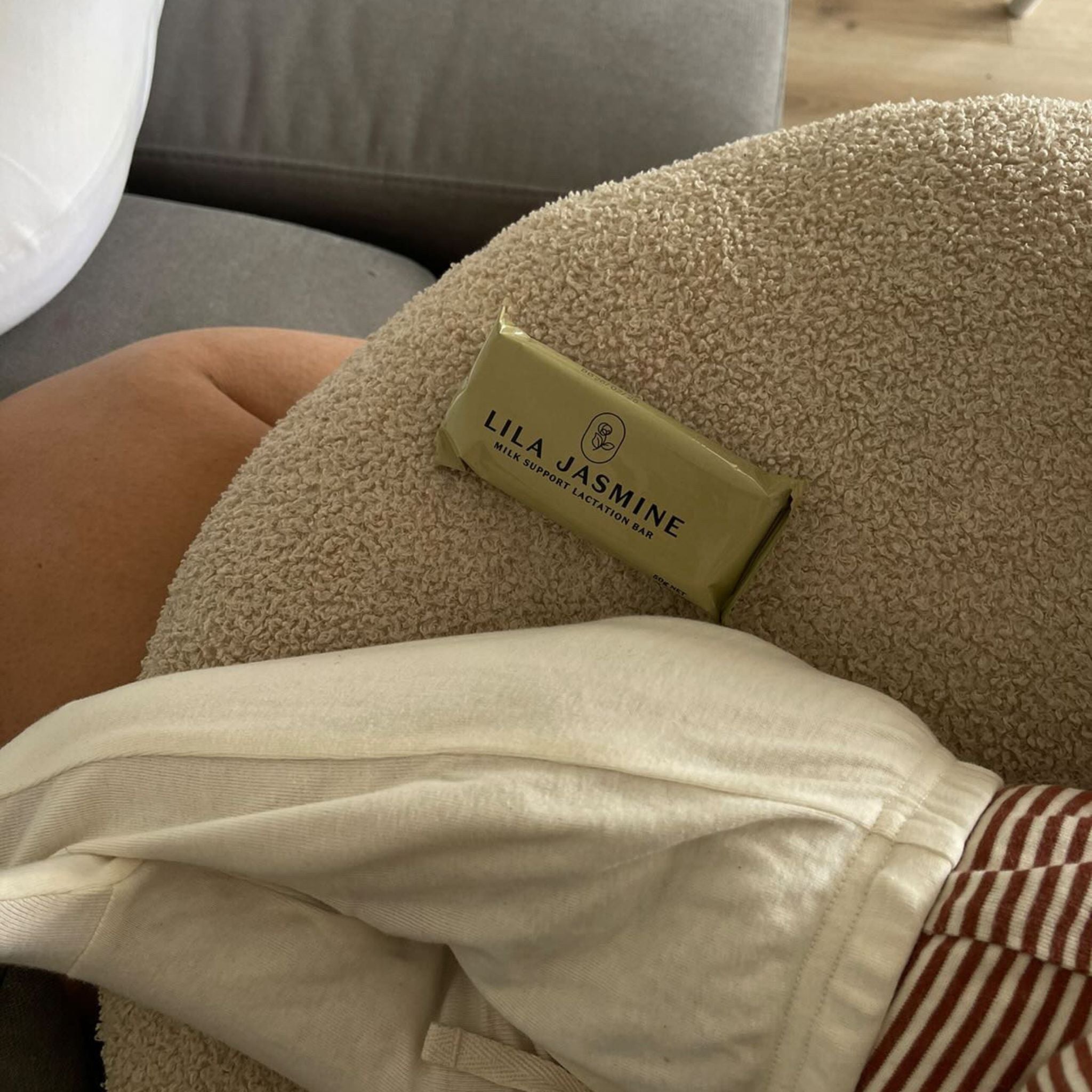 Looking for a lactation cookie alternative? New mum enjoying an Apple Crumble Lactation Bar while breastfeeding her baby. On-the-go convenience.