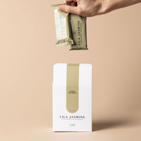 Hand holding a Apple Crumble Lila Jasmine milk support lactation bars against a beige background