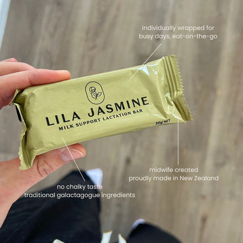 Hand holding a Lila Jasmine milk support lactation bar with text on a wooden background with text of product features