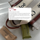 A close-up flat lay of a beige canvas diaper bag . A white review card is overlaid in the center with a customer testimonial.