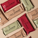 Flatlay of Lila Jasmine milk support lactation bars in various colours on a beige background.