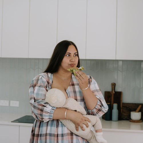 Looking for a lactation cookie alternative? New mum enjoying an Apple Crumble Lactation Bar while breastfeeding her baby. Eat anywhere, anytime. Enjoy single-handed.